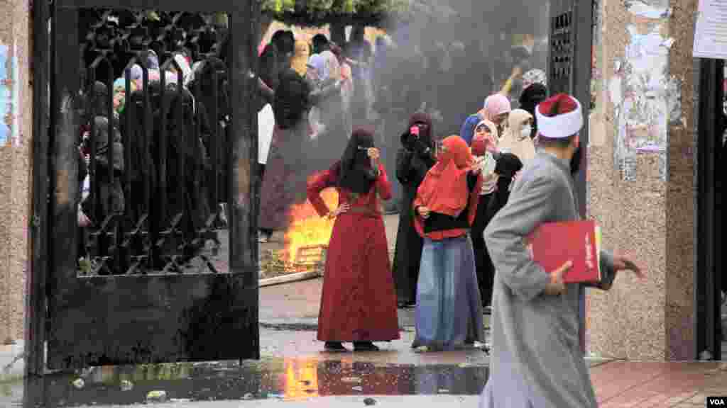 Female Islamist students burn debris during a protest at Al-Azhar University in Cairo, Dec. 11, 2013. (Hamada Elrasam for VOA)