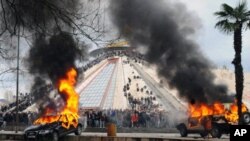 反对派周五在地拉那与警方发生冲突后，汽车在燃烧