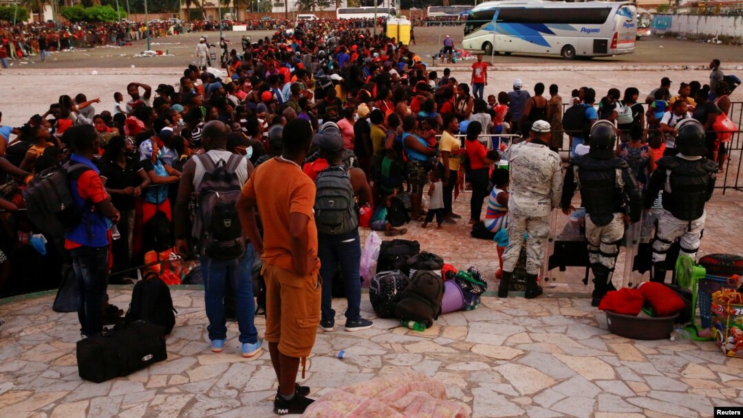 Migrantes hacen fila para abordar un autobús luego de aceptar una oferta del gobierno mexicano para obtener visas humanitarias para transitar por territorio mexicano, en Tapachula, México, el 4 de diciembre de 2021. 