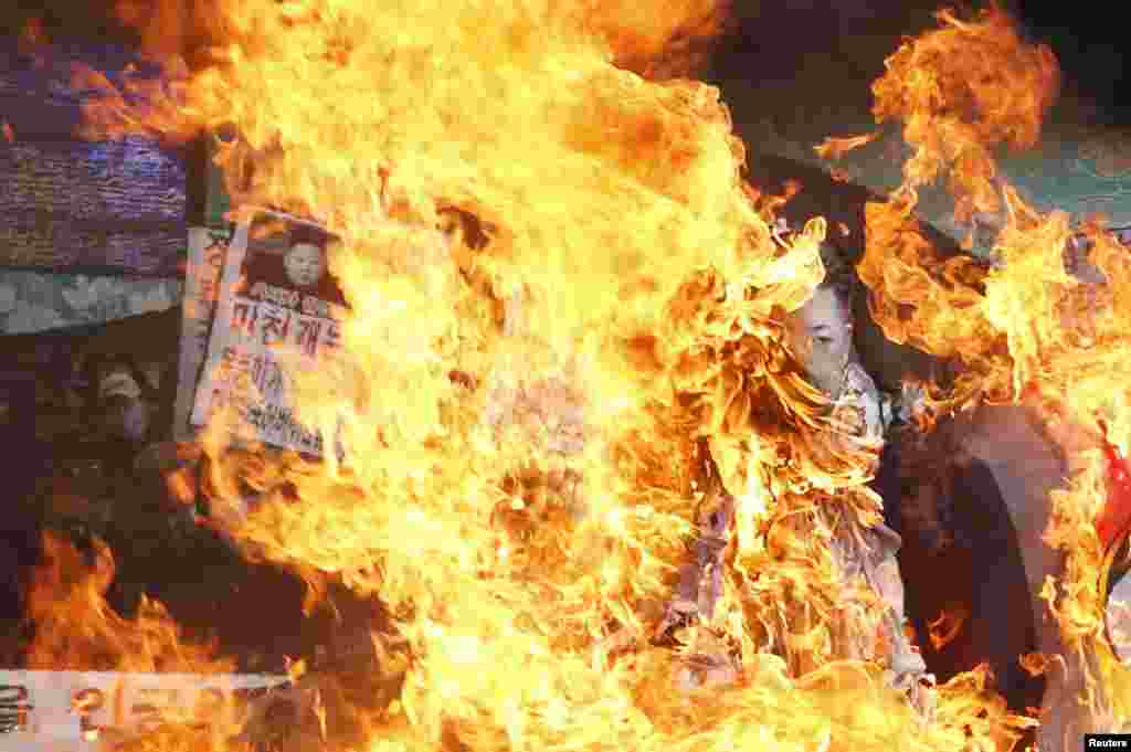 Anti-North Korean protesters burn an effigy of North Korea's leader Kim Jong-Un and its flag during a protest blaming the North's rocket launch in central Seoul December 12, 2012. North Korea successfully launched a rocket on Wednesday, boosting the crede