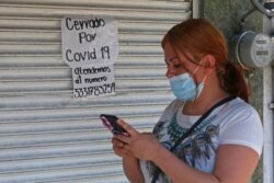 Una persona llama por teléfono a un comercio cerrado por las medidas para frenar la pandemia de coronavirus en la Ciudad de México en mayo de 2020.