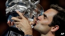 Switzerland's Roger Federer holds his trophy aloft after defeating Croatia's Marin Cilic during the men's singles final at the Australian Open tennis championships in Melbourne, Australia, Jan. 28, 2018.