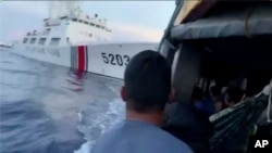 Potongan gambar yang dirilis oleh Filipina menunjukkan anggota AL Filipina melihat ke arah kapal penjaga pantai China sesaat sebelum kedua kapal berbenturan di dekat Second Thomas Shoal, di Laut China Selatan pada 22 Oktober 2023. (Foto: Armed Forces of the Philippines via AP)