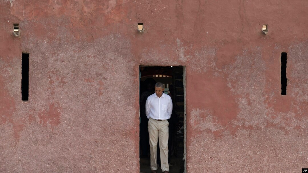 FILE - Former U.S. President Barack Obama looks down as he approaches the 'Door of No Return,' through which slaves once passed as they boarded ships for the Americas, at the slave house on Goree Island, in Dakar, Senegal, June 27, 2013.