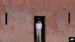 FILE - Former U.S. President Barack Obama looks down as he approaches the 'Door of No Return,' through which slaves once passed as they boarded ships for the Americas, at the slave house on Goree Island, in Dakar, Senegal, June 27, 2013.