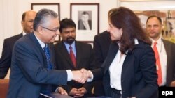 Le vice-Premier ministre et ministre des Finances et du Développement économique de Maurice, Pravind Kumar Jugnauth, à gauche, et le directeur général adjoint du Fonds monétaire international (FMI) Mme Nemat Shafik, à droite, se serrent la main après une cérémonie de signature d’un accord au siège du FMI, à Washington, DC, 18 avril 2011.