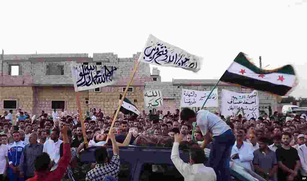 In this citizen journalism image provided by Shaam News Network SNN, Syrians attend the funeral procession of a man killed in Idlib province, August 7, 2012.