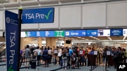 FILE - Air passengers heading to their departure gates enter TSA precheck before going through security screening at Orlando International Airport, June 21, 2018, in Orlando, Fla.