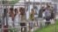 FILE - Asylum-seekers look through a fence at the Manus Island detention center in Papua New Guinea, March 21, 2014. 