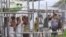 FILE - Asylum-seekers look through a fence at the Manus Island detention center in Papua New Guinea, March 21, 2014. 