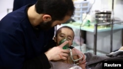 A man with a child at a hospital in the besieged town of Douma, Eastern Ghouta, Damascus, Syria February 25, 2018. 