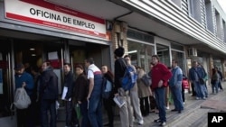 People line up to enter a government employment benefit office in Madrid on Monday, April 4, 2011