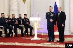 Presiden Rusia Vladimir Putin menganugerahkan medali Bintang Emas Pahlawan Rusia kepada prajurit pada malam Hari Pahlawan Tanah Air di Aula St. George di Grand Kremlin. (Foto: AFP)