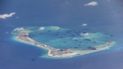 FILE - Chinese dredging vessels are purportedly seen the waters around Mischief Reef in the disputed Spratly Islands in the South China Sea in this video image taken by a P-8A Poseidon surveillance aircraft provided by the U.S. Navy, May 21, 2015.