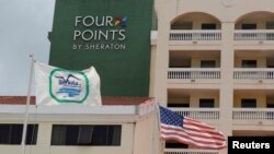 A U.S. flag and a flag of the Cuban military-run hospitality company Gaviota flutter near the logo of a "Four Points by Sheraton" hotel in Havana, Cuba, June 27, 2016. 