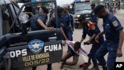 Pasukan keamanan bentrok dengan pendukung capres Kongo, Martin Fuyulu, di luar kantor markas partainya di Kinshasa, Republik Demokratik Kongo, Rabu, 27 Desember 2023. (Foto: Samy Ntumba Shambuyi/AP Photo)