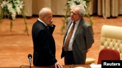 Mehdi al-Hafidh, right, the acting speaker of Iraq's newly elected parliament, talks to Iraq's former Prime Minister Ibrahim Jafari at the first session of the Iraqi parliament in Baghdad, July 1, 2014. 