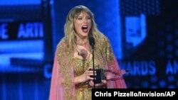 Taylor Swift accepts the award for artist of the decade at the American Music Awards, at the Microsoft Theater in Los Angeles, California, Nov. 24, 2019. 