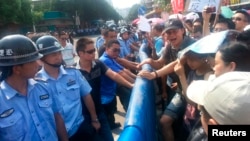 Police face off with demonstrators protesting plans for a nuclear facility in Jiangmen, Guangdong province, July 12, 2013.