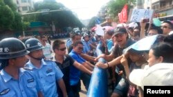 Polisi China berhadapan dengan demonstran yang memprotes rencana pembangunan fasilitas nuklir di Jiangmen, Provinsi Guangdong (12/7).