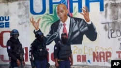 Ba policiers ba telemi pene na photo ya président Jovenel Moise ya Haïti oyo akufi na masasi na Port-au-Prince, Haiti, le 7 juillet 2021. 