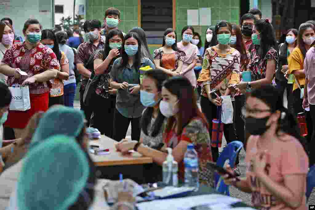 People line up as they wait for their turn to get a shot of the Sinovac COVID-19 vaccine during a mass vaccination at Putri Hijau Military Hospital in Medan, North Sumatra, Indonesia.