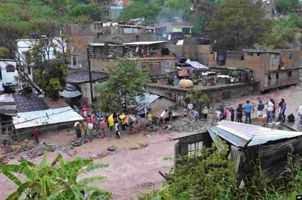 Warga mencari jenazah dan menyelamatkan harta mereka setelah hujan besar memicu tanah longsor di perumahan kumuh di kota Chilpancingo, negara bagian Guerrero, Meksiko (16/9). (AP/Alejandrino Gonzalez)