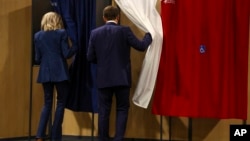 El presidente francés Emmanuel Macron y su esposa Brigitte Macron entran en una cabina de votación durante las elecciones europeas, el domingo 9 de junio de 2024 en Le Touquet-Paris-Plage, al norte de Francia.
