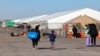 Para migran yang tiba beberapa hari lalu dari Eagle Pass, Texas, berjalan menuju tempat penampungan migran di Floyd Bennett Field, bekas bandara militer di Brooklyn, New York, 3 Februari 2024. (Charly TRIBALLEAU / AFP)