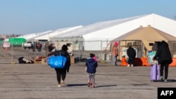 Para migran yang tiba beberapa hari lalu dari Eagle Pass, Texas, berjalan menuju tempat penampungan migran di Floyd Bennett Field, bekas bandara militer di Brooklyn, New York, 3 Februari 2024. (Charly TRIBALLEAU / AFP)