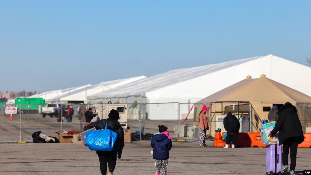 FILE - Migrants who arrived a few days ago from Eagle Pass, Texas, walk to the shelters at Floyd Bennett Field in the Brooklyn borough of New York on Feb. 3, 2024.