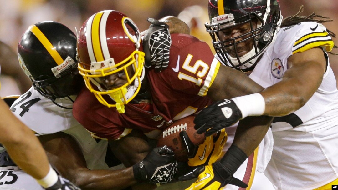 Ryan Clark, Ike Taylor y Jarvis Jones, todos de los Steelers bloquean a Josh Morgan (15), de los Redskings, en juego de pretemporada ganado por Washington.