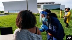 Kendria Brown, una enfermera de Washington DC, vacuna a una mujer con la vacuna COVID-19 el 6 de mayo de 2021, cerca del Kennedy Center.