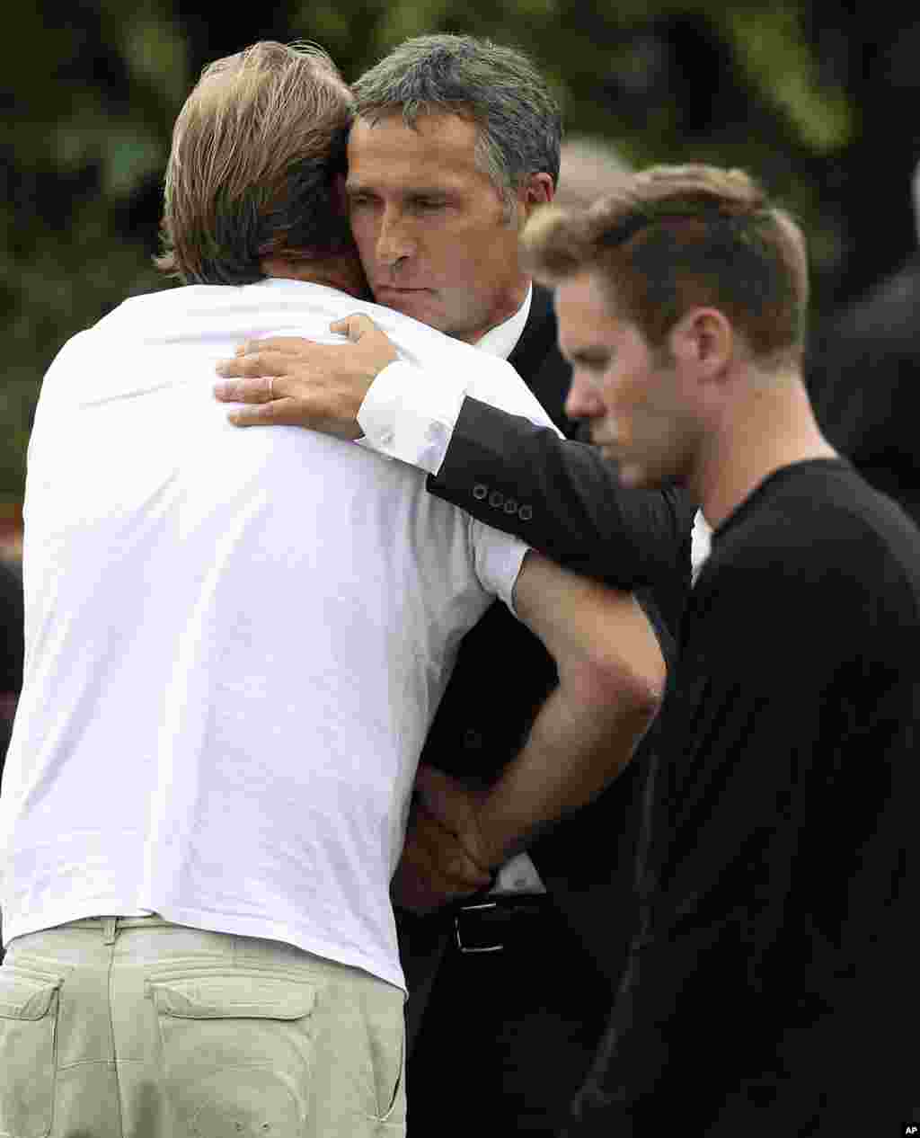 Prime Minister Jens Stoltenberg (C) hugs a man as he comforts survivors and family members at a hotel in Sundvollen, northwest of Oslo. (Reuters)