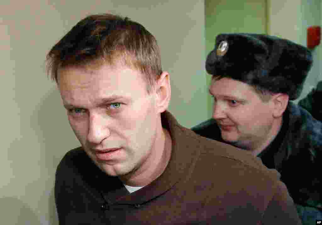 December 6: Russian blogger, political and social activist Alexei Navalny , who was detained during a protest a day before, is escorted to attend hearings at Tverskoi district court in Moscow.  (REUTERS/Anton Golubev)