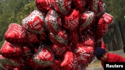 Seorang anak laki-laki menjual balon berbentuk hati pada Hari Valentine di Islamabad, Pakistan, 14 Februari 2017. (REUTERS/Faisal Mahmoo)