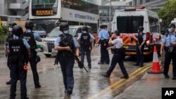 Police officers stand guard outside a court in Hong Kong, Aug. 19, 2021. Seven Hong Kong pro-democracy activists have reportedly pleaded guilty Thursday to organizing and inciting others to take part in an unauthorized assembly held in 2019.