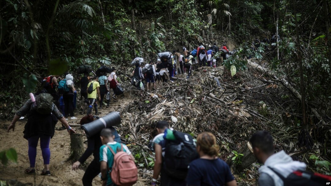 Sejumlah migran tampak berjalan melewati area Celah Darien dari Kolombia menuju Panama untuk mencapai AS, pada 9 Mei 2023. (Foto: AP/Ivan Valencia)