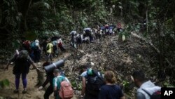 Sejumlah migran tampak berjalan melewati area Celah Darien dari Kolombia menuju Panama untuk mencapai AS, pada 9 Mei 2023. (Foto: AP/Ivan Valencia)