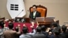 South Korea's ruling People Power Party lawmakers, bottom, argue to National Assembly Speaker Woo Won-shik during the plenary session for the impeachment vote of acting president Han Duck-soo at the National Assembly in Seoul on Dec. 27, 2024.