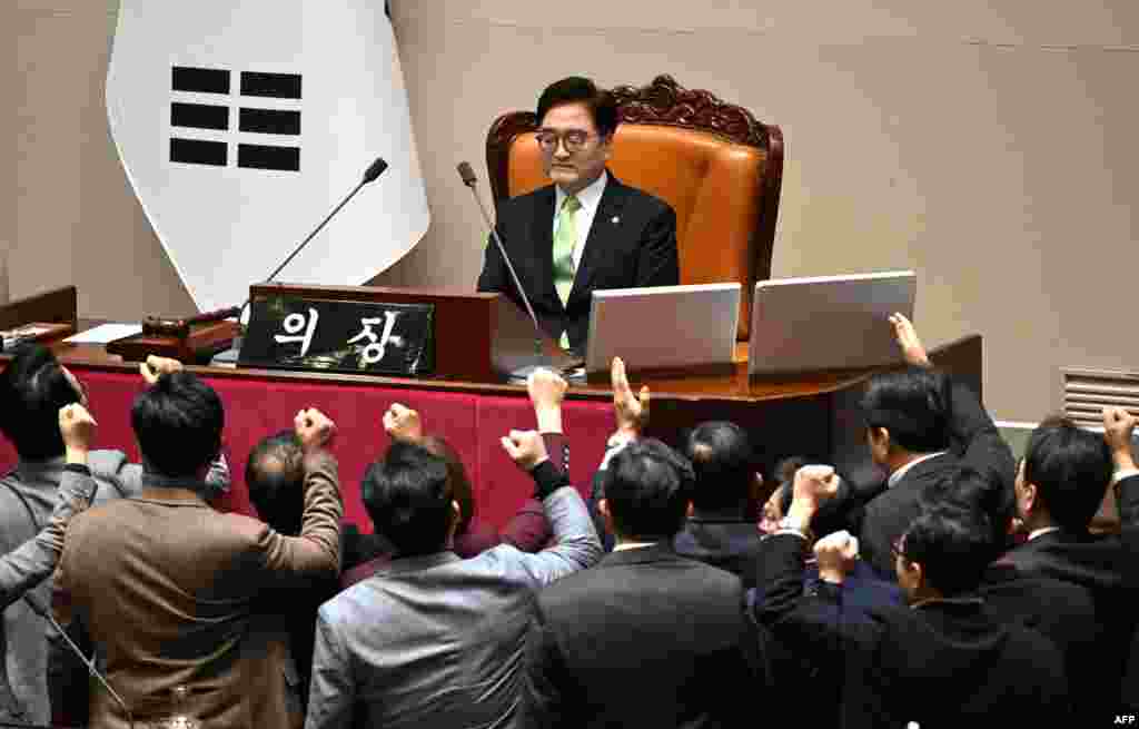 South Korea&#39;s ruling People Power Party lawmakers, bottom, argue to National Assembly Speaker Woo Won-shik during the plenary session for the impeachment vote of acting president Han Duck-soo at the National Assembly in Seoul.&nbsp;(Photo by JUNG YEON-JE / AFP)