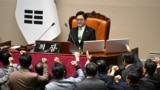 South Korea's ruling People Power Party lawmakers, bottom, argue to National Assembly Speaker Woo Won-shik during the plenary session for the impeachment vote of acting president Han Duck-soo at the National Assembly in Seoul on Dec. 27, 2024.