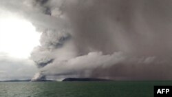 Dalam gambar yang diambil pada 26 Desember 2018 dari sebuah kapal yang melintas di Selat Sunda, tampak Gunung Anak Krakatau erupsi. (Foto: AFP).