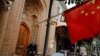 Seorang pria tampak di belakang bendera China di Kota Tua di Kashgar di
Wilayah Autonomi Xinjiang Uighur, China, 6 September 2018. (Foto: Reuters)