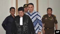 Gubernur Jakarta Basuki "Ahok" Tjahaja Purnama (tengah) didampingi para jaksa saat memasuki ruang sidang untuk pemeriksaan hukuman di Jakarta, Indonesia, 9 Mei 2017.(Bay Ismoyo/Pool Photo via AP).