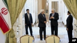 Iranian Foreign Minister Mohammad Javad Zarif, 2nd left, talks with U.N. and Arab League envoy on Syria Lakhdar Brahimi, 2nd right, as they arrive at their joint press conference in Tehran, Iran, Oct. 26, 2013. 