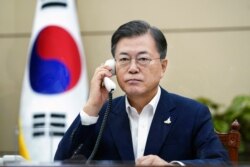 FILE - South Korean President Moon Jae-in talks on the phone with Japanese Prime Minister Yoshihide Suga at the presidential Blue House in Seoul, South Korea, Sept. 24, 2020.