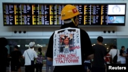 Más de 1.000 personas vestidas de negro llenaron la sala de llegadas del Aeropuerto Internacional de Hong Kong, donde recibieron a los visitantes extranjeros.