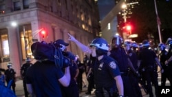 A police officer shouts at Associated Press videojournalist Robert Bumsted, Tuesday, June 2, 2020, in New York. New York City police officers surrounded, shoved and yelled expletives at two Associated Press journalists covering protests Tuesday in…