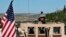 FILE - A U.S. soldier sits in his armored vehicle on a road leading to the front line in Manbij, Syria, April 4, 2018.